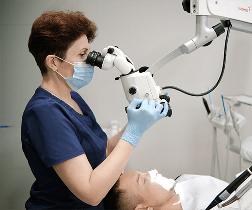Dental Pluss zobārste darbā ar zobārstniecības mikroskopu