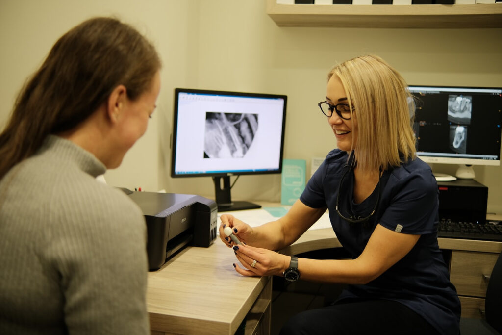 Zobārste konsultē pacientu par zobu implantāciju Dental Pluss klīnikā